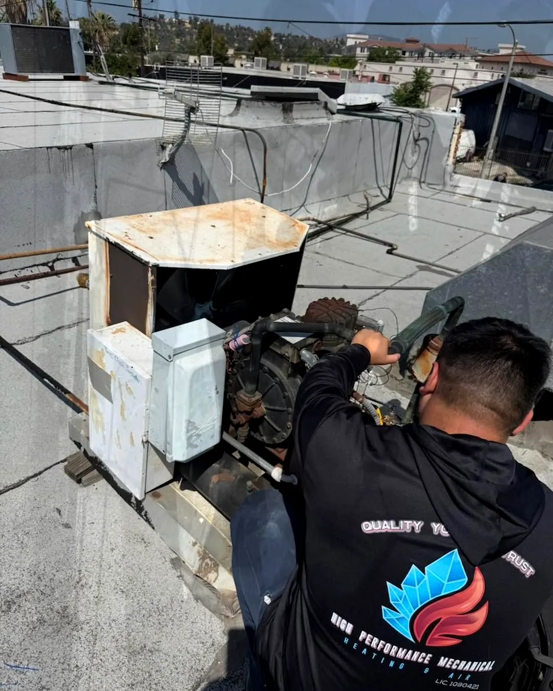 High Performance Mechanical technician servicing equipment on a commercial rooftop